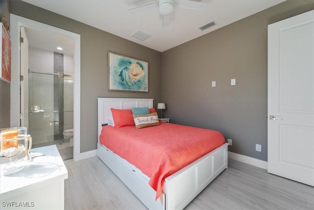 bedroom featuring visible vents, ensuite bath, light wood-style floors, and baseboards