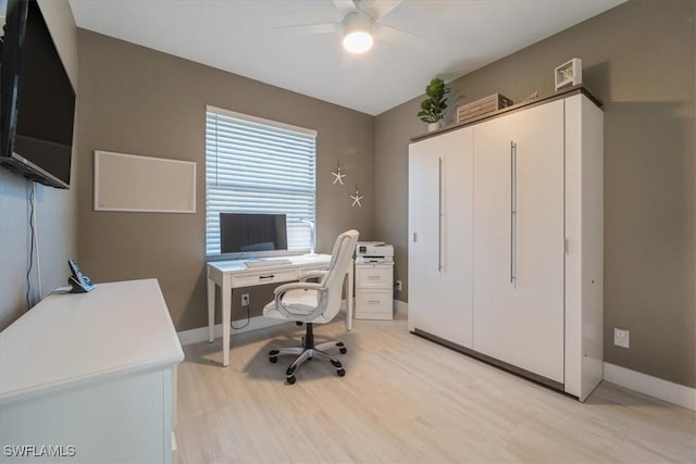 home office featuring baseboards, a ceiling fan, and light wood finished floors