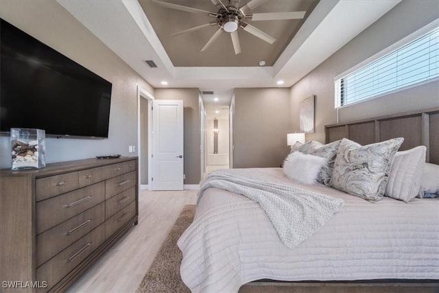 bedroom featuring visible vents, a raised ceiling, recessed lighting, light wood-style floors, and baseboards