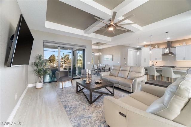 living room featuring light wood-type flooring, beam ceiling, coffered ceiling, baseboards, and ceiling fan