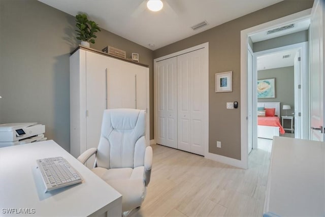 office space with visible vents, baseboards, and light wood finished floors