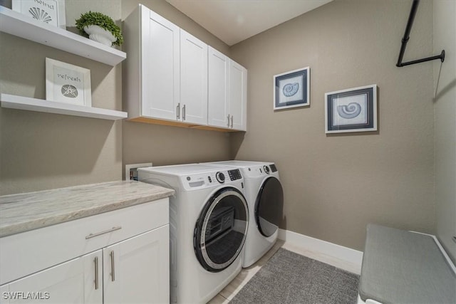 laundry area featuring baseboards, cabinet space, and washing machine and clothes dryer