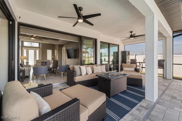 view of patio featuring an outdoor living space with a fire pit and a ceiling fan