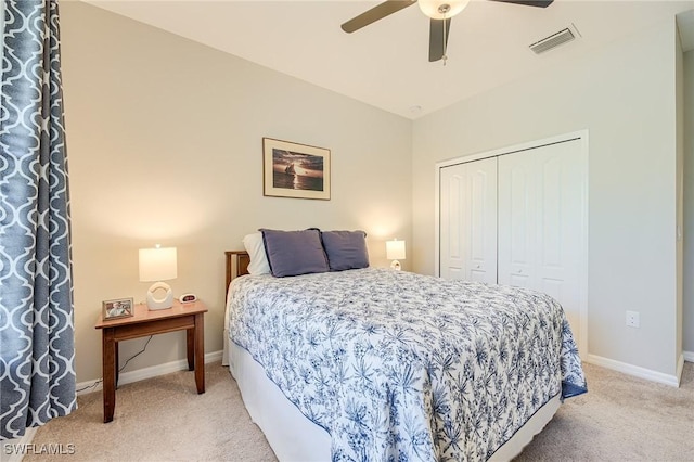 bedroom with ceiling fan, a closet, and light carpet