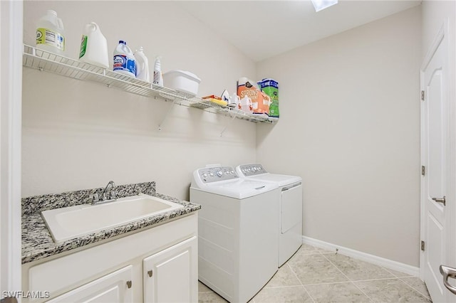 washroom featuring washing machine and clothes dryer, light tile patterned flooring, cabinets, and sink