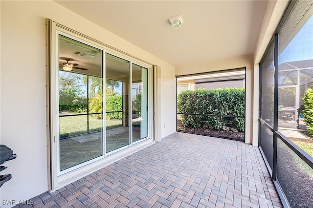 unfurnished sunroom featuring ceiling fan