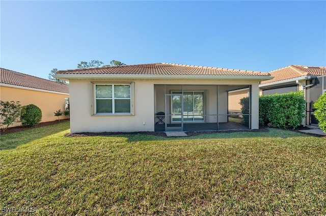 rear view of house with a sunroom and a yard