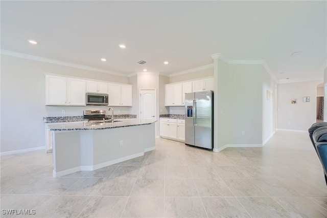 kitchen featuring appliances with stainless steel finishes, crown molding, a center island with sink, stone countertops, and white cabinetry