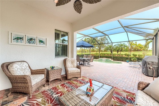 view of patio featuring glass enclosure, area for grilling, and pool water feature