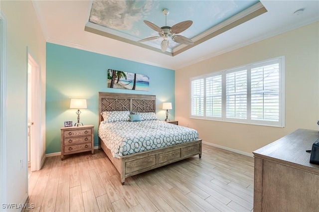 bedroom with ceiling fan, crown molding, light hardwood / wood-style flooring, and a raised ceiling