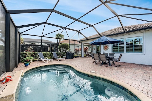 view of swimming pool with a lanai, pool water feature, a grill, and a patio