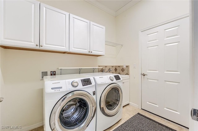 laundry room with washer and clothes dryer, light tile patterned flooring, crown molding, and cabinets