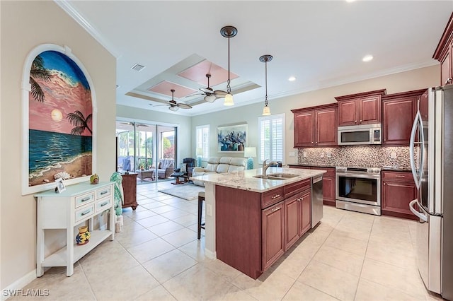 kitchen with decorative light fixtures, stainless steel appliances, sink, ceiling fan, and a tray ceiling