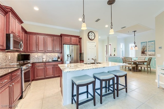 kitchen featuring crown molding, appliances with stainless steel finishes, dark stone countertops, and sink