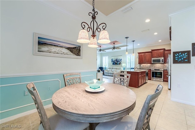 tiled dining space with ceiling fan with notable chandelier and ornamental molding