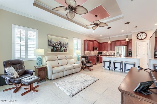 tiled living room featuring ceiling fan, crown molding, and a tray ceiling