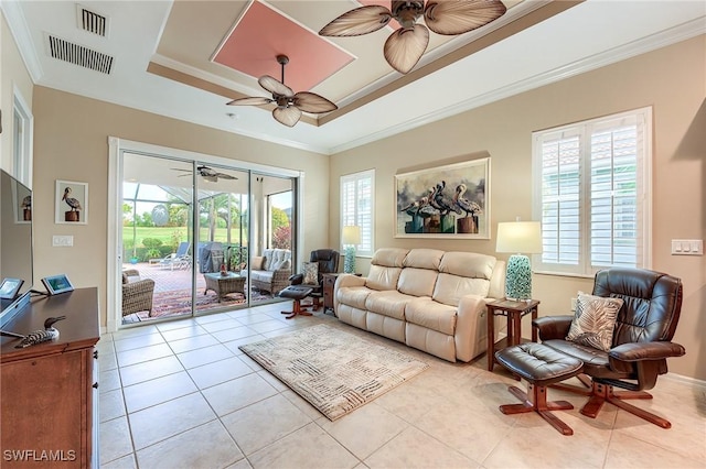 tiled living room featuring ornamental molding and a raised ceiling