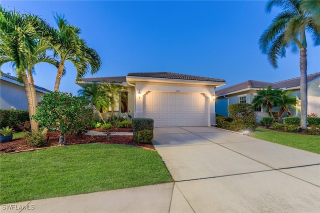 mediterranean / spanish home featuring a garage and a front yard