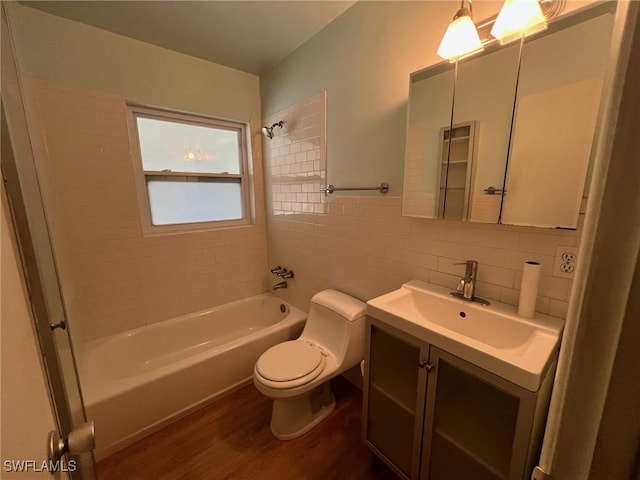 full bathroom with hardwood / wood-style floors, vanity, tiled shower / bath combo, toilet, and tile walls