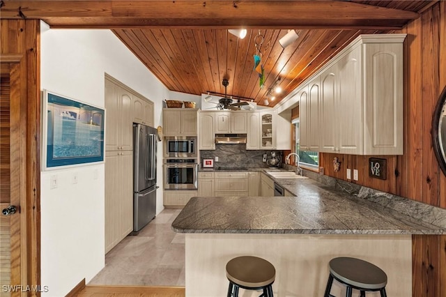 kitchen with a breakfast bar area, kitchen peninsula, lofted ceiling with beams, and appliances with stainless steel finishes