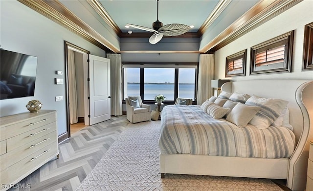 bedroom with ceiling fan, a water view, ornamental molding, and light parquet floors