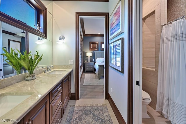 bathroom featuring a shower with curtain, vanity, ornamental molding, and toilet