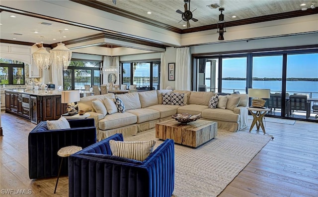 living room with ceiling fan with notable chandelier, light wood-type flooring, a water view, and ornamental molding