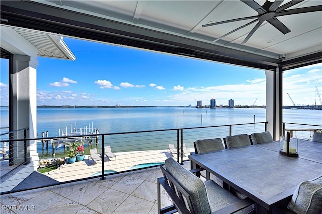 balcony with ceiling fan and a water view