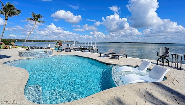 view of swimming pool with a patio area, a water view, a dock, and an in ground hot tub