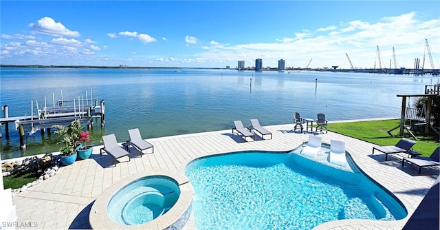 view of pool with an in ground hot tub, a patio, a water view, and a dock