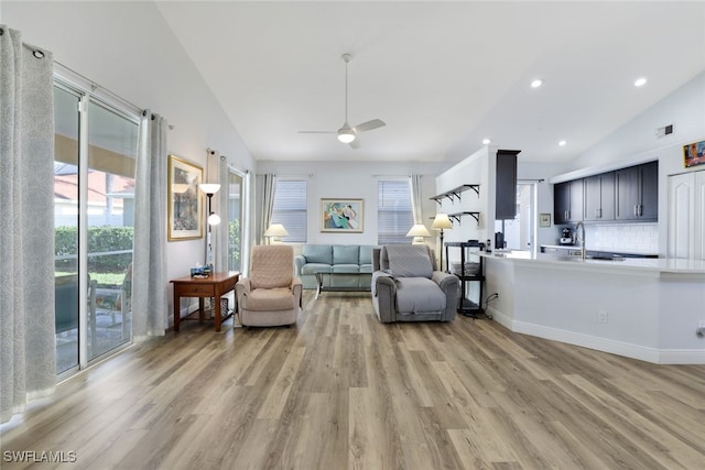 sitting room with light wood-type flooring, ceiling fan, lofted ceiling, and sink