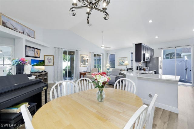 dining area featuring plenty of natural light, ceiling fan, light wood-type flooring, and vaulted ceiling