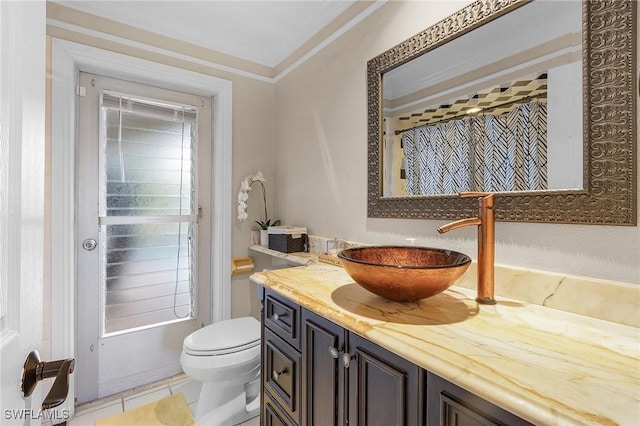 bathroom with tile patterned flooring, vanity, toilet, and ornamental molding