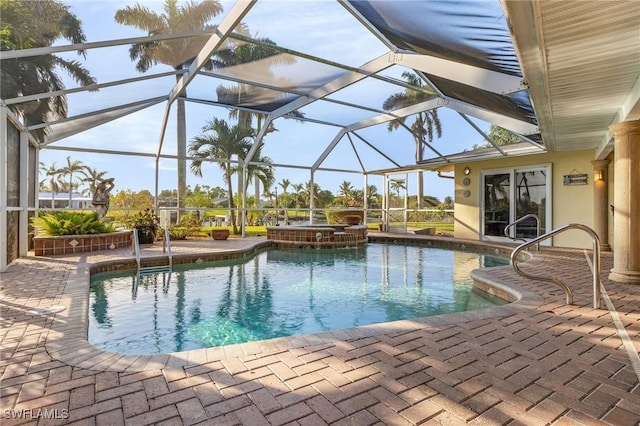 view of swimming pool featuring a patio area, a lanai, and an in ground hot tub