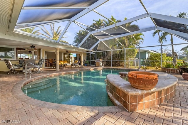 view of pool with a lanai, ceiling fan, and a patio