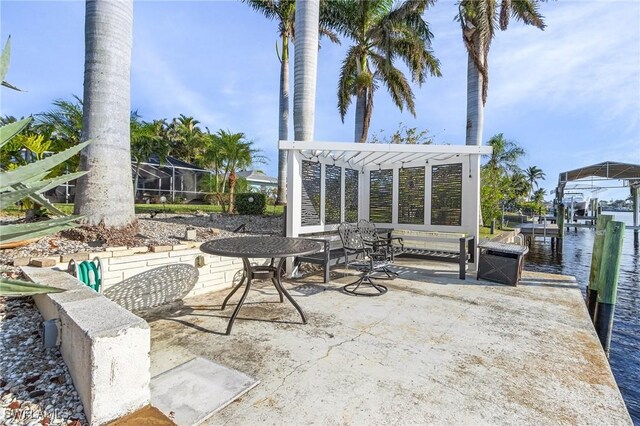 view of patio with a boat dock, a water view, and a pergola