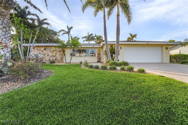 ranch-style house featuring a front yard and a garage