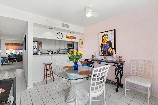 dining area with light tile patterned floors, visible vents, and a ceiling fan