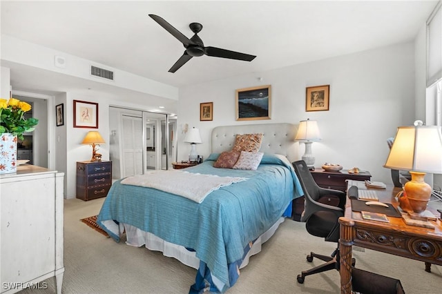 bedroom with a closet, visible vents, ceiling fan, and light carpet