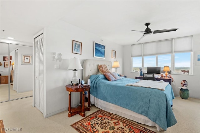 bedroom with a ceiling fan, a closet, and light colored carpet