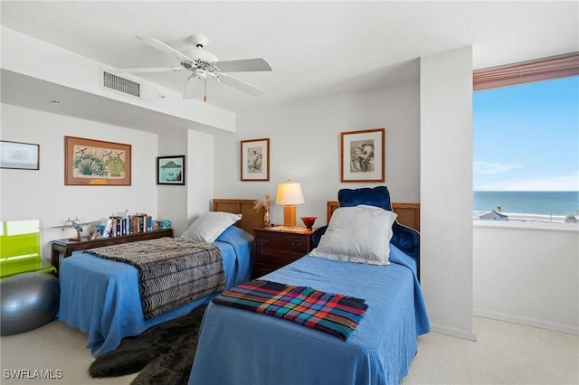 bedroom featuring light carpet, baseboards, visible vents, a ceiling fan, and a water view