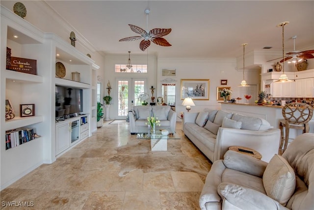 living room with built in shelves, ceiling fan, french doors, and ornamental molding