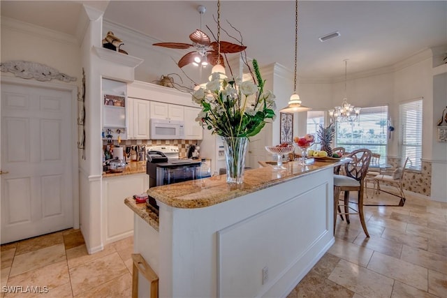 kitchen featuring a center island, stainless steel electric stove, hanging light fixtures, light stone counters, and white cabinetry