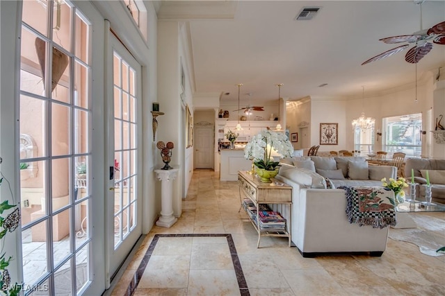 living room with crown molding and ceiling fan with notable chandelier