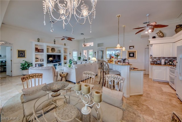 dining area featuring ceiling fan with notable chandelier and crown molding