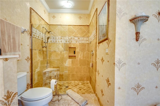 bathroom with toilet, ornamental molding, and a tile shower