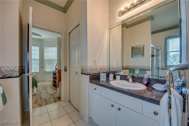 bathroom with tile patterned flooring, vanity, and crown molding