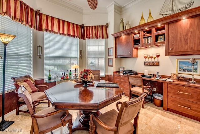 dining room with built in desk and ornamental molding