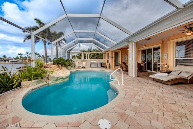 view of swimming pool featuring ceiling fan, a patio area, and a lanai