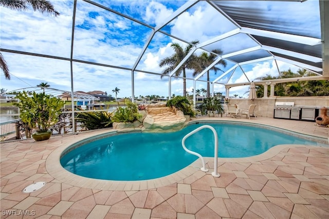 view of pool with a patio, glass enclosure, and exterior kitchen